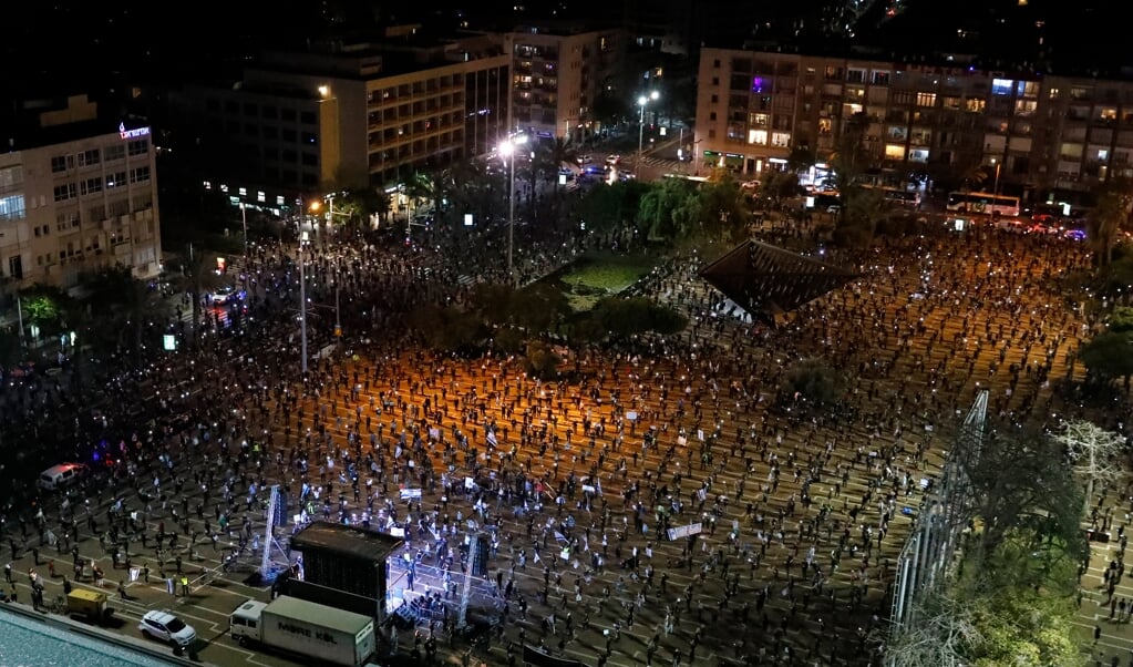 De doorbraak in de politieke onderhandelingen in Israël kwam een dag het 'zwarte vlagprotest' door duizenden burgers in Tel Aviv. De demonstranten hielden twee meter afstand wegens de coronacrisis. (beeld afp / Jack Guez)