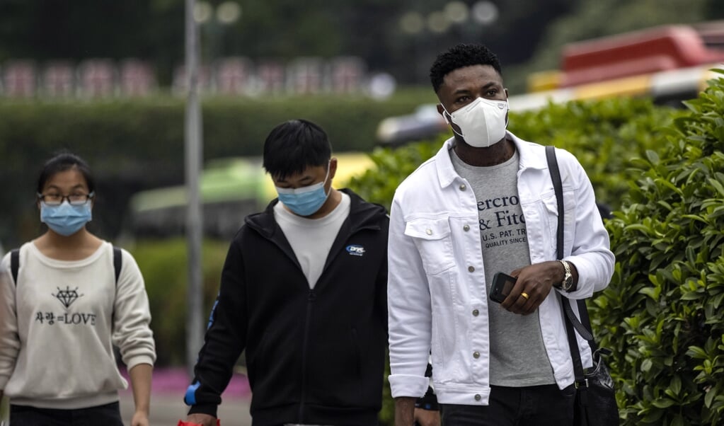 Een Afrikaanse man loopt op straat in het zogeheten Afrikaanse dorp in Guangzhou, China. (beeld epa / Alex Plavevski)