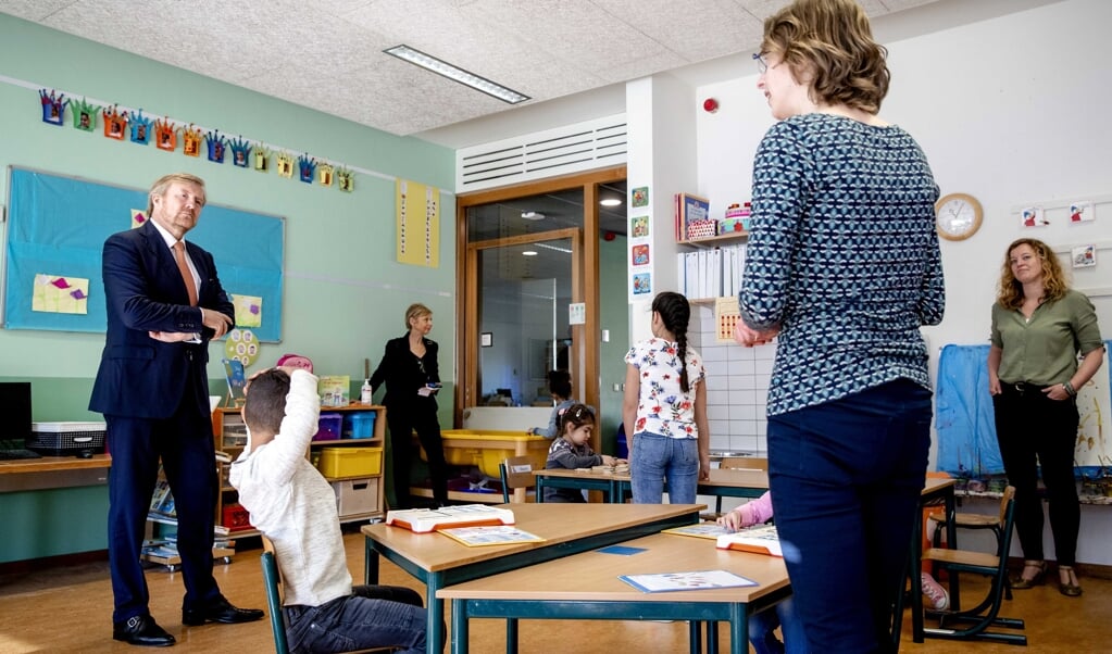 Koning Willem-Alexander bracht deze week een werkbezoek aan een klas met leerlingen van ouders met vitale beroepen. (beeld epa / Sem van der wal)
