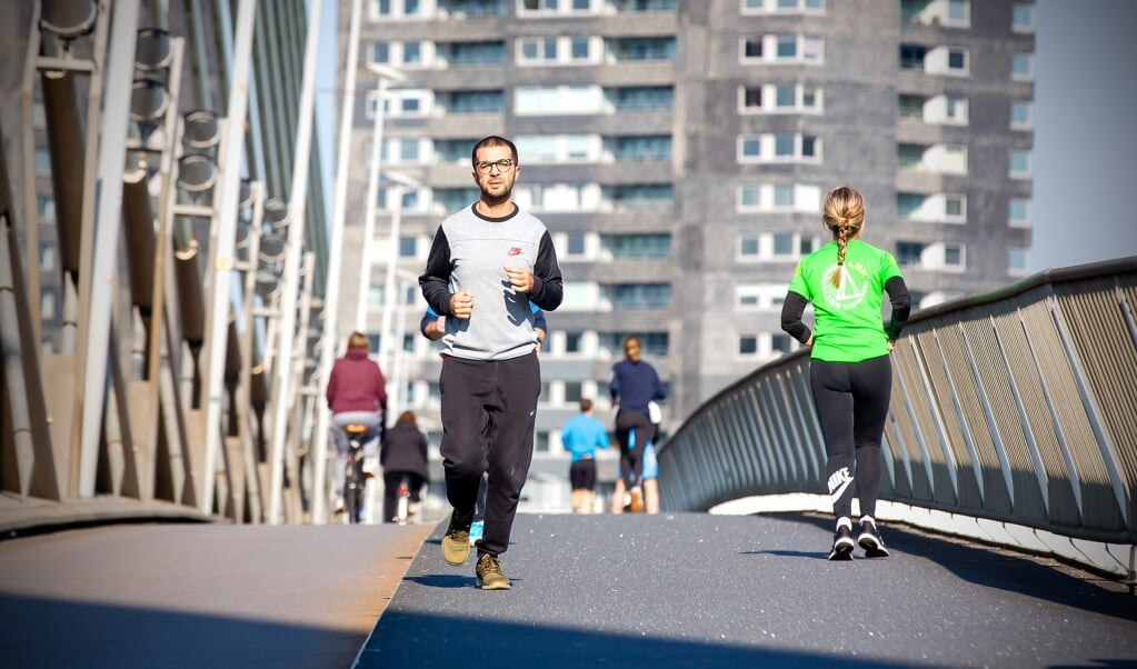 Hardlopers lopen over de Erasmusbrug op de dag dat de marathon Rotterdam zou plaatsvinden, 4 april 2020. (beeld anp / Bart Hoogveld)