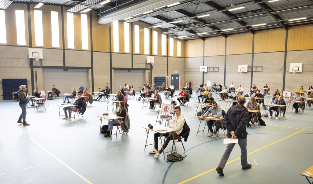 In de grote gymzaal zwoegen in normale tijden 210 leerlingen op hun examen. Nu buigen zestig havo-leerlingen zich over de wiskunde A-toets. (beeld Niek Stam )
