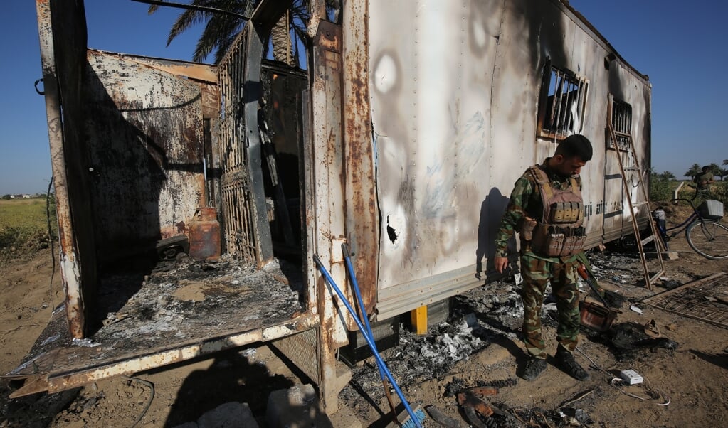 Een lid van de Iraakse Volksmobilisatie Beweging PMU bekijkt de schade van een aanslag door ISIS in het Noord-Iraakse Mukaishefah. (beeld afp / Ahmad al-Rubaye)