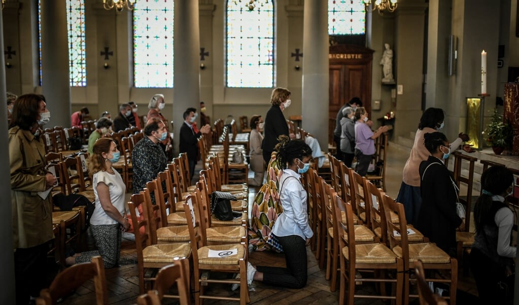 In de Saint Jean-Baptiste-kerk in een buitenwijk van Parijs komen mensen voor het eerst weer samen voor de mis. Frankrijk heeft het samenkomen in godsgebouwen na weken van beperkingen weer toegestaan. (beeld AFP)