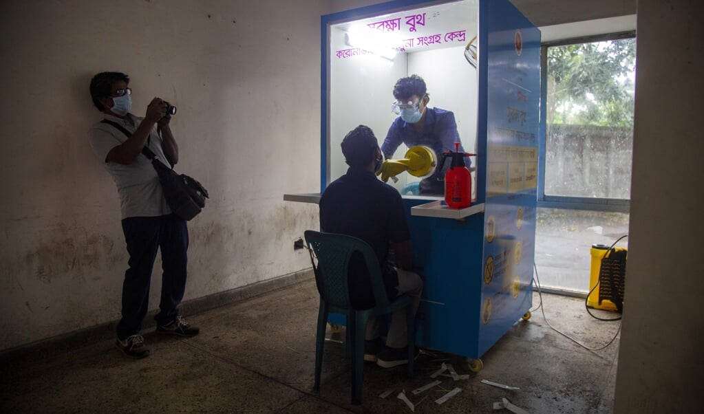 2020-05-21 00:00:00 epa08436631 A health official (C-R) wearing a mask collects a swab sample from a journalist (C) at the National Press Club in Dhaka, Bangladesh, 21 May 2020 (issued 22 May 2020). Countries around the world are taking increased measures to stem the widespread of the SARS-CoV-2 coronavirus which causes the COVID-19 disease. EPA/MONIRUL ALAM (beeld epa / Monirul Alam)