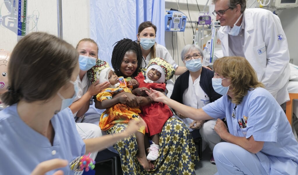 Tweelingzusjes Ervina en Prefina met hun moeder na de operatie in het Vaticaanse kinderziekenhuis Bambino Gesu. (beeld Bambino Gesu Hospital / afp)