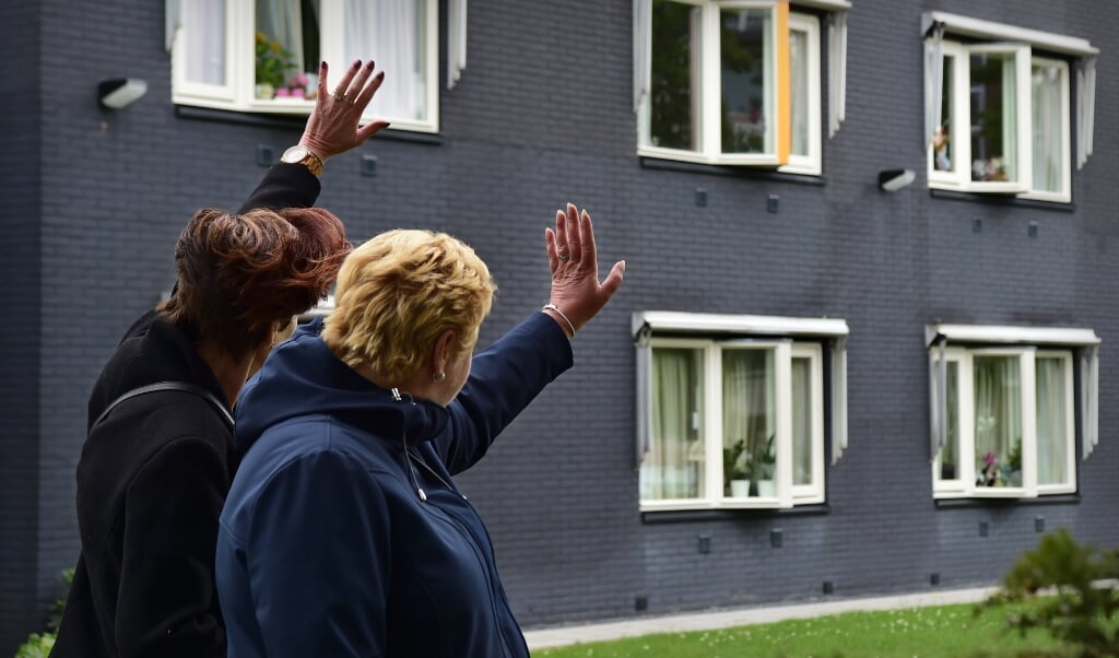 29-6-2020, Nederland, Maassluiscoronavirus In verpleegtehuis De Tweemaster is de bezoekregeling meteen stopgezet nadat bij diverse bewoners besmetting van het coronavirus is vastgesteld. Opnieuw komen de bewoners in een isolement te zitten. Het virus blijkt zeker nog niet verdwenen. Twee zussen hebben van ver contact met hun moeder en zwaaien als ze weer vertrekken. coronavirus; virus; corona; pandemie; ziekte; RIVM; sociale onthouding; coronacrisis; COVID-19; anderhalvemetersamenleving; anderhalvemetermaatschappij; verpleegtehuis; verzorgingstehuis; ouderen; De Tweemaster; coronavirus; bezoekverbod; sociaal isolement; foto Marcel van den Bergh (beeld Marcel van den Bergh)