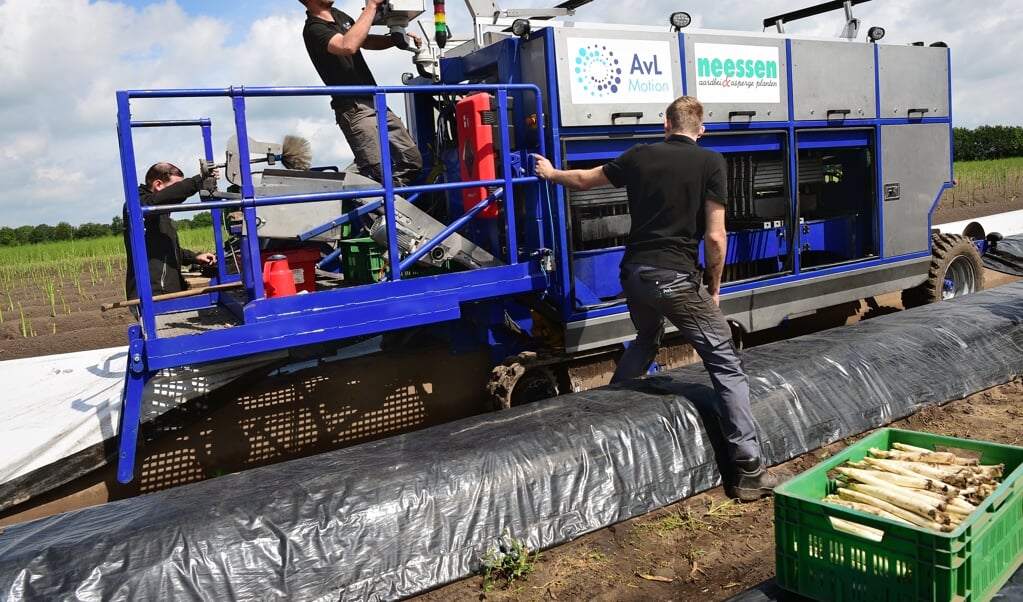 Een aspergeteler automatiseert en schaft een aspergesteekmachine aan. Technici installeren de machine. (beeld Marcel van den Bergh)