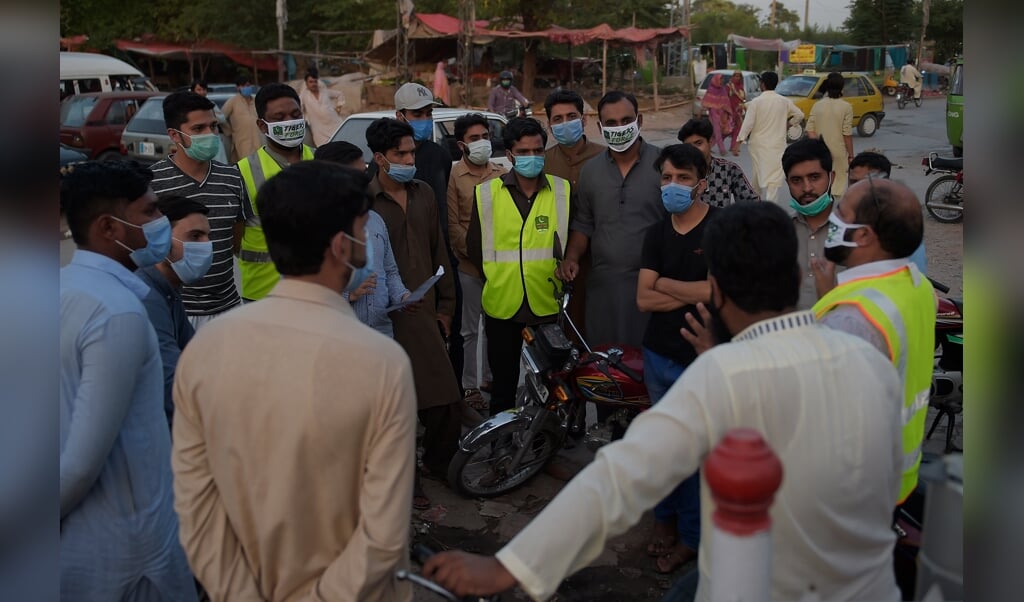 De Pakistaanse premier Imran Khan stuurt vrijwilligersteams het land in om mensen bewust te maken van corona. Volgens CGK Diaconie concentreert de hulp van de Pakistaanse overheid zich vooral op moslims. (beeld AFP)