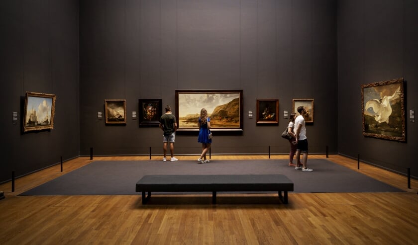 Bezoekers bekijken schilderijen in het Rijksmuseum in Amsterdam. Tot nu toe was gepland dat de Museumvereniging de officiële inspectie van de rijksmusea zou uitvoeren. (beeld anp / Robin van Lonkhuijsen)