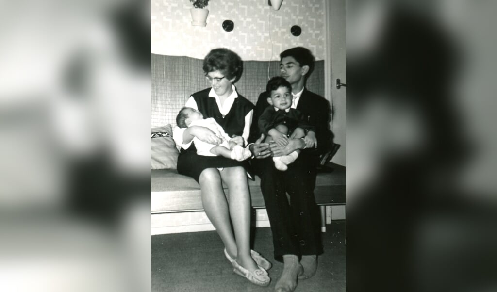 Ronald Hünnenman, hier bij zijn vader opschoot: 'Mijn ouders, mijn jongere broer en ik' (1963). 'Als mijn lichtere broer en ik samen met mijn moeder over straat liepen, riep ze wel eens lachend naar een buurvrouw: 'Ja hoor, deze is van de melkboer'. (beeld nd)