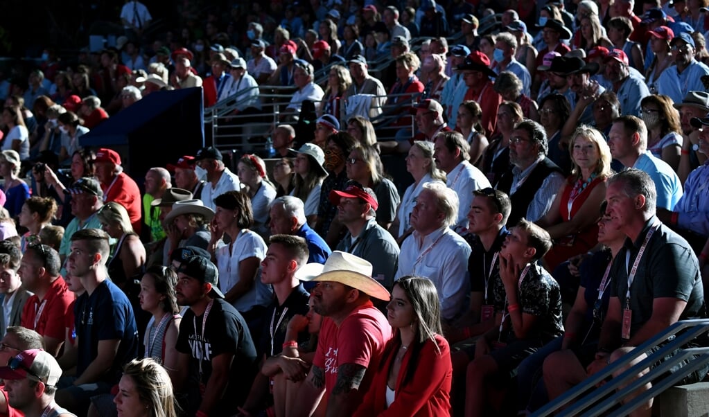Aanhangers luisteren naar president Trump tijdens de bijeenkomst bij Mount Rushmore op 3 juli, voorafgaand aan Onafhankelijkheidsdag. De ongeveer 7500 aanwezigen droegen nauwelijks mondkapjes en hielden geen afstand van elkaar. 'Voorbij onverantwoordelijk', noemden artsen het optreden van de president. (beeld AFP / Saul Loeb)
