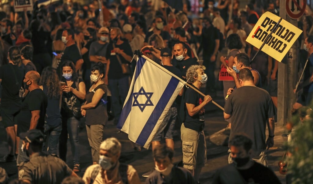 Duizenden Israëliërs protesteren iedere dag tegen premier Benjamin Netanyahu. Een 'groot thema' ontbreekt echter, zegt onderzoeker Padan. (beeld afp / Ahmad Gharabli)