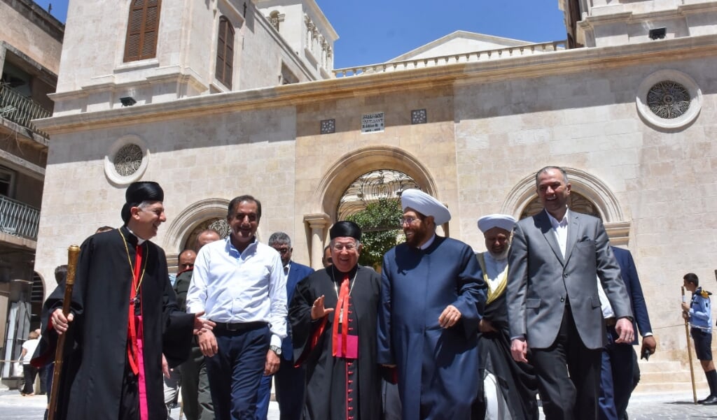 Aartsbisschop Joseph Tobji van Aleppo (links) met aartsbisschop Paul Youssef Matar uit Beiroet (midden), en de grootmoefti van Syrië Ahmed Hassoun (tweede van rechts) vlak na de heropening van de maronitische kathedraal in Aleppo. (beeld afp)