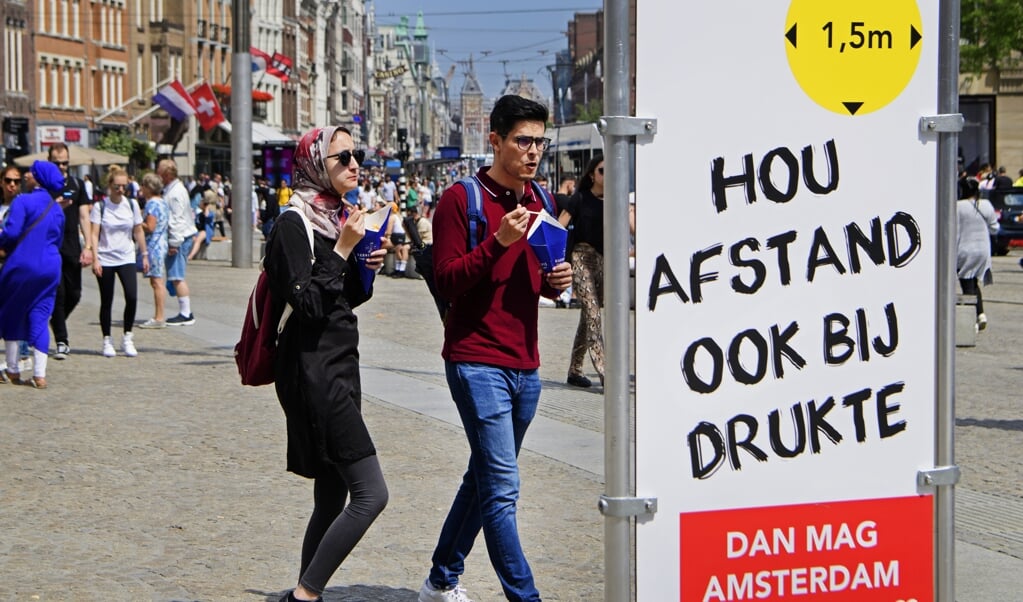 Een informatiebord in het centrum. De Veiligheidsregio Amsterdam-Amstelland neemt extra maatregelen vanwege de toenemende drukte in de binnenstad. (beeld anp / Olaf Kraak)