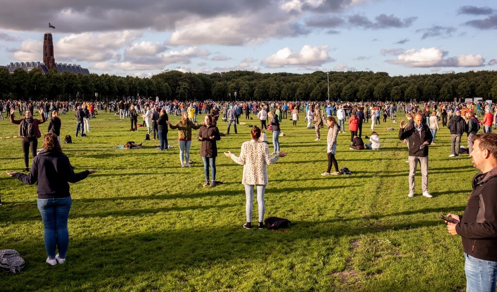 Zo'n tweeduizend mensen baden en zongen vrijdagavond op het Malieveld in Den Haag. (beeld Dirk Hol )