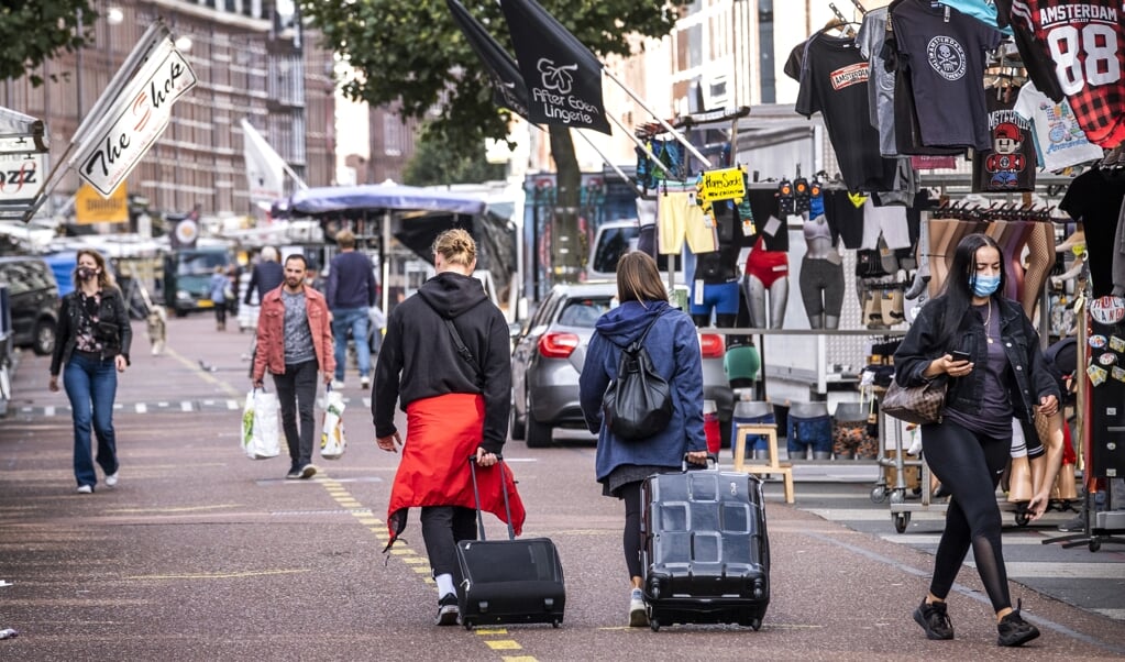 <p>Toeristen op de Amsterdamse Albert Cuypmarkt. In Amsterdam heeft Airbnb niet bij iedereen een goede naam, omdat de Amerikanen worden gezien als ontwrichters van de woningmarkt.</p> (beeld anp / Ramon van Flymen)