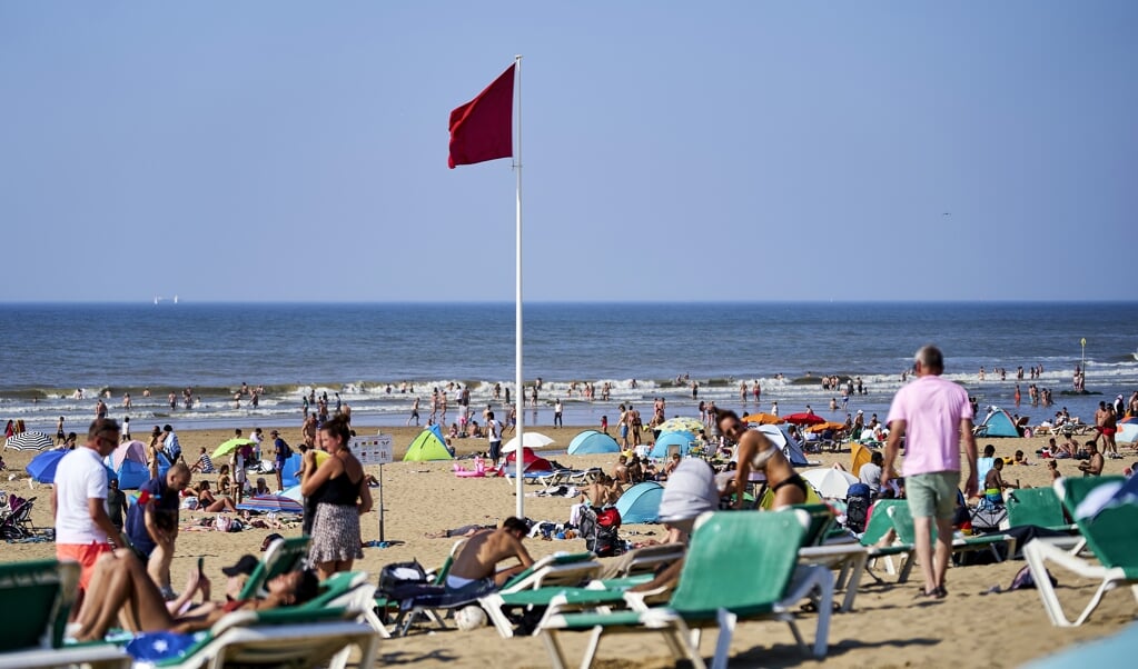 De rode vlag op het strand van Scheveningen, waar stroming en wind zorgen voor een verraderlijke zee. (beeld anp / Phil Nijhuis)