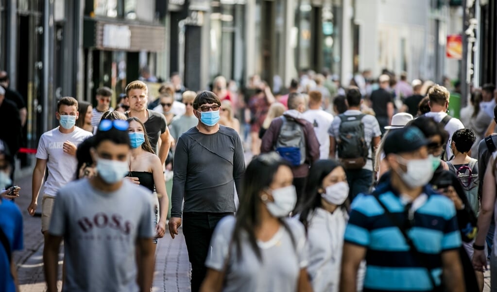 Winkelend publiek in de Kalverstraat in Amsterdam. Op vijf plekken in de stad is het dragen van een mondkapje inmiddels verplicht gesteld. (beeld anp / Remko de Waal)