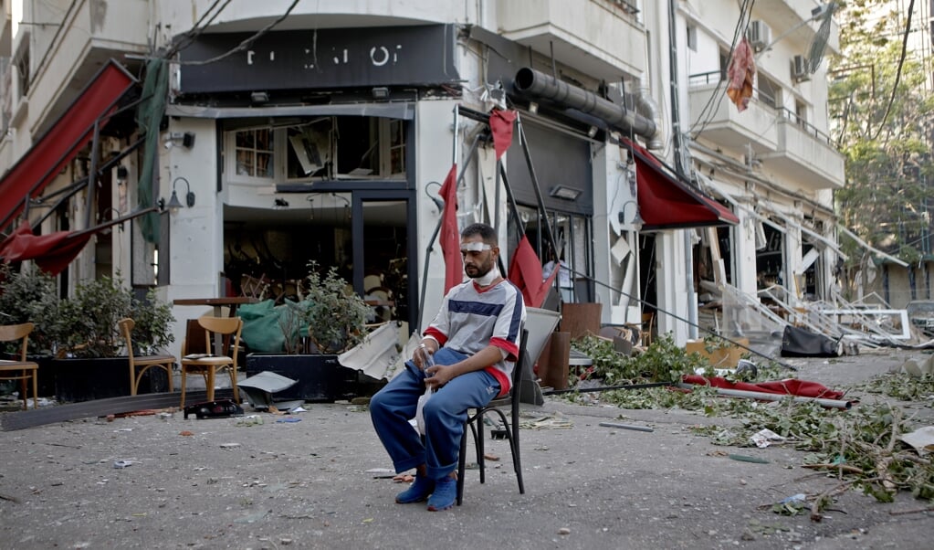 De explosie komt net nu Libanon failliet is, de banken nauwelijks functioneren en plunderingen op de loer liggen. (beeld afp / Patrick Baz)