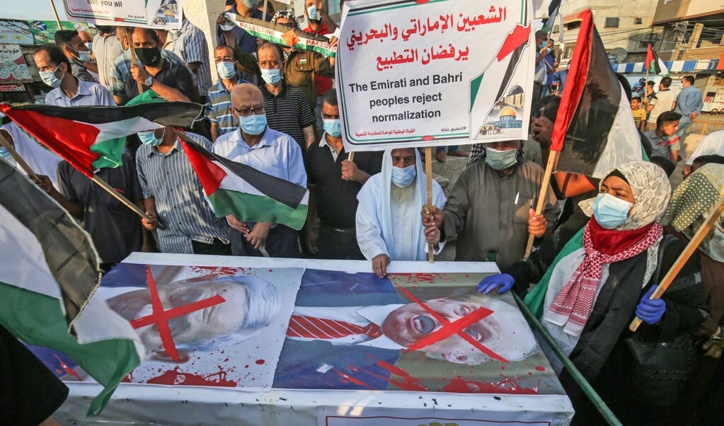 <p>Palestijnen protesteren in Rafah, in de Gazastrook, tegen de Abraham-akkoorden van de Verenigde Arabische Emiraten en Bahrein met Israël.</p> (beeld AFP / Said Khatib)