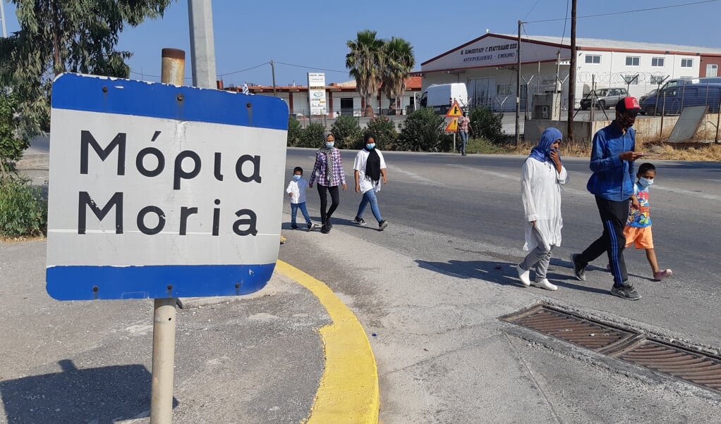 <p>Vluchtelingen lopen van het nieuwe vluchtelingen kamp naar de plaatselijke Lidl of het afgebrande kamp.</p> (beeld Hendro Munsterman)