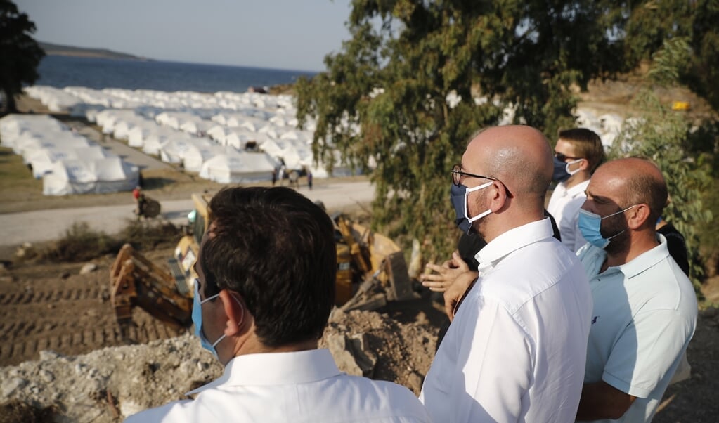 <p>Een delegatie van de Europese Commissie kijkt hoe op Lesbos in enkele dagen tijd een nieuw tijdelijk opvangkamp uit de grond is gestampt.</p> (beeld epa / Dimitris Tosidis)