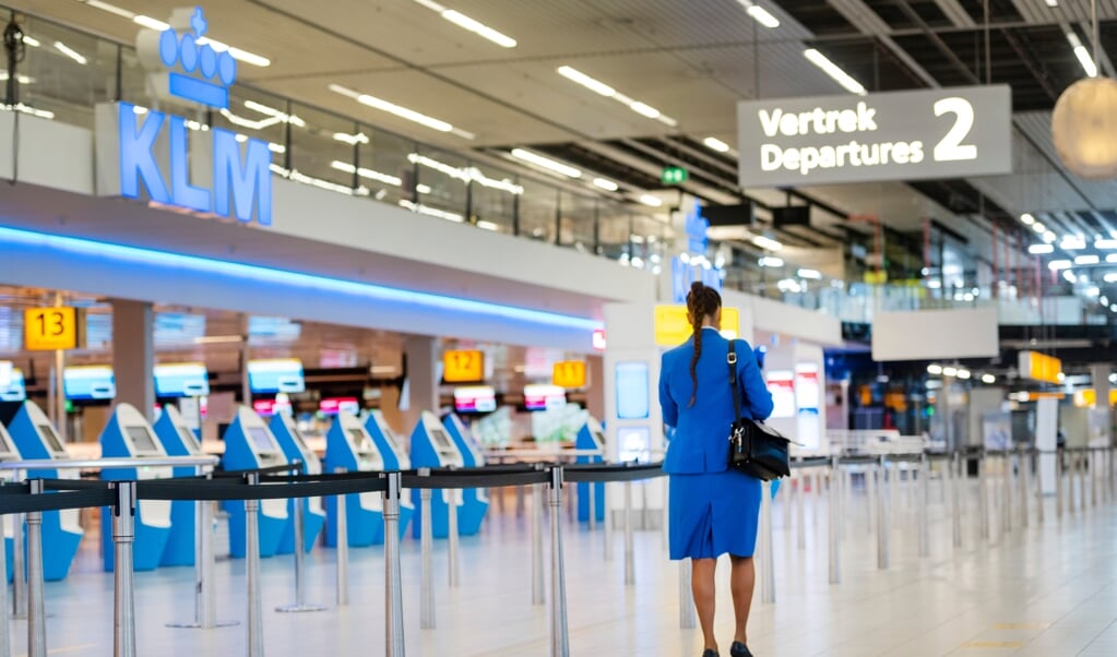 Een KLM-stewardess op Schiphol. Bij KLM verdwijnen nog eens achthonderd tot duizend banen als gevolg van de coronacrisis. (beeld anp / Evert Elzinga)