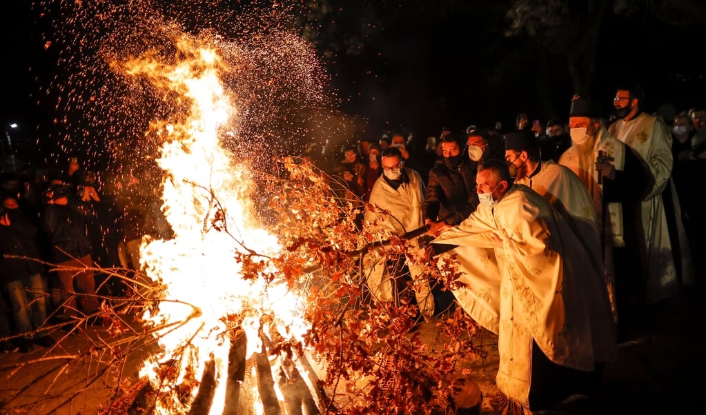 2021-01-06 19:12:09 epa08923169 Kosovo Serb priests burn dried oak branches, the Yule log symbol for the Orthodox Christmas Eve, in front of the 14th century Gracanica monastery, in Gracanica, Kosovo, 06 January 2021. Orthodox Serbs are celebrating Christmas on 07 January according to the old Julian calendar. EPA/VALDRIN XHEMAJ (beeld epa / Valdrin Xhemaj)