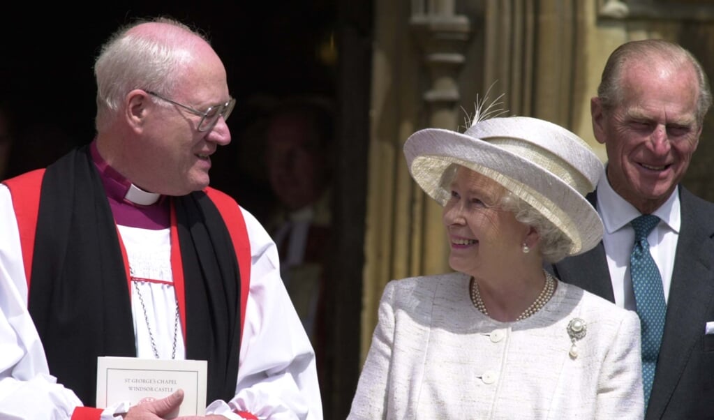 George Carey (links) in gesprek met de Britse Queen Elizabeth op een archieffoto uit 2002. (beeld afp / Martin Hayhow)