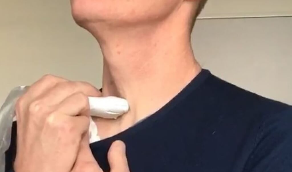 Een vrijwilliger houdt de kop van een echoapparaat tegen zijn keel tijdens het zingen. (beeld Steve Beuve)