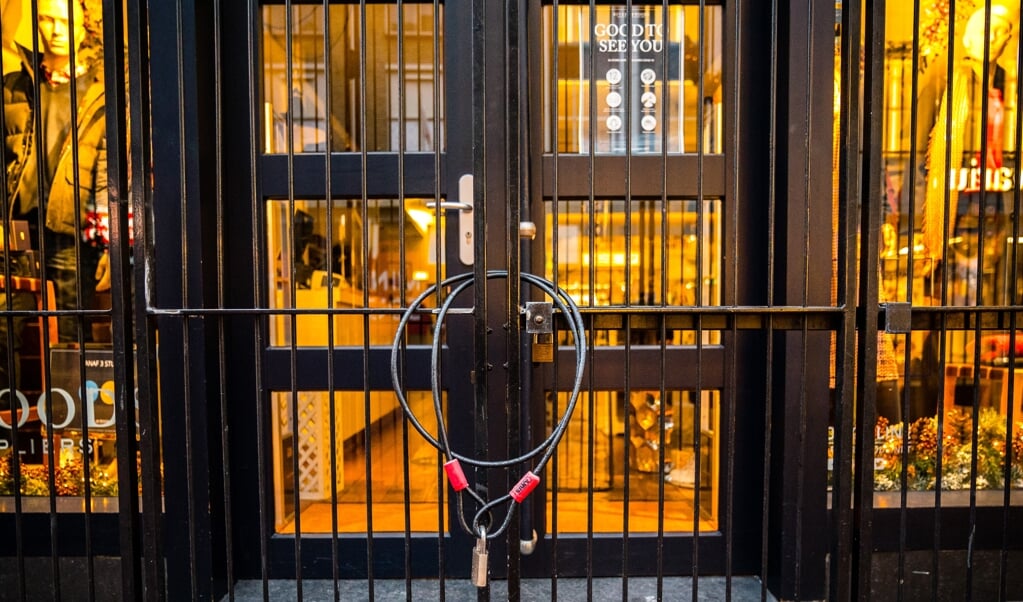 Een winkeldeur is afgesloten met een slot in de binnenstad van Eindhoven. (beeld anp / rob Engelaar)
