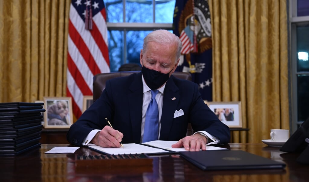 Op zijn eerste werkdag in het Witte Huis ondertekent president Joe Biden een aantal decreten. (beeld afp / Jim Watson)
