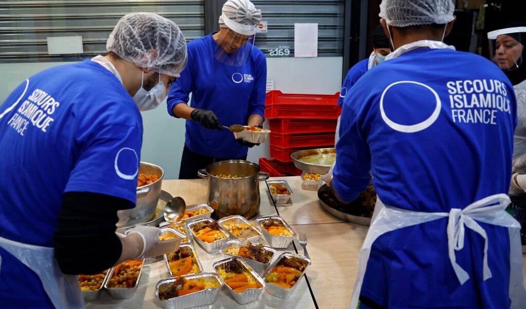 Vrijwilligers van de Franse tak van Islamic Relief bereidden vorig jaar tijdens de Ramadan voedsel voor moslims die arm zijn. (beeld Thomas Coex / afp)