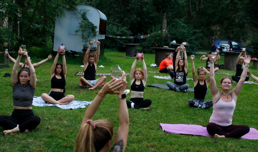 2020-08-08 20:19:08 epa08592499 People practice during a Wine Yoga event in Riga, Latvia, 08 August 2020. EPA/Valda Kalnina (beeld Epa/valda Kalnina)