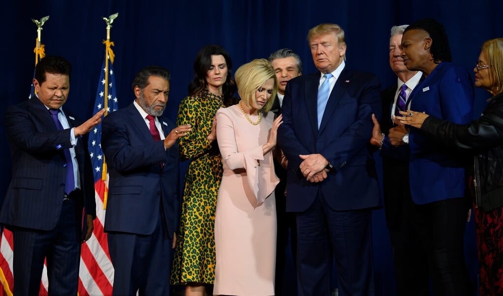 Voorgangers van verschillende kerken bidden voor president Donald Trump tijdens de laatste verkiezingscampagne. Veel predikanten voorspelden een overwinning. (beeld afp / Jim Watson)