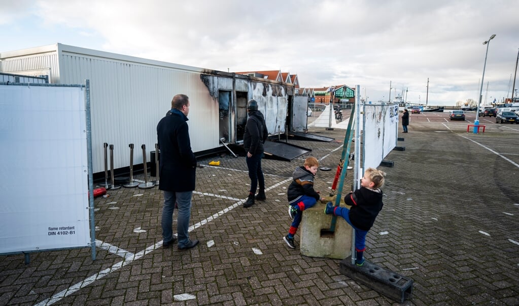 Brandschade bij de coronateststraat van de GGD op het haventerrein, waar tientallen jongeren protesteerden na het ingaan van de avondklok. Een noodbevel werd afgekondigd en de marechaussee stonden klaar om in te grijpen, waarna de rust terugkeerde in het vissersdorp. (beeld anp / Jeroen Jumelet)