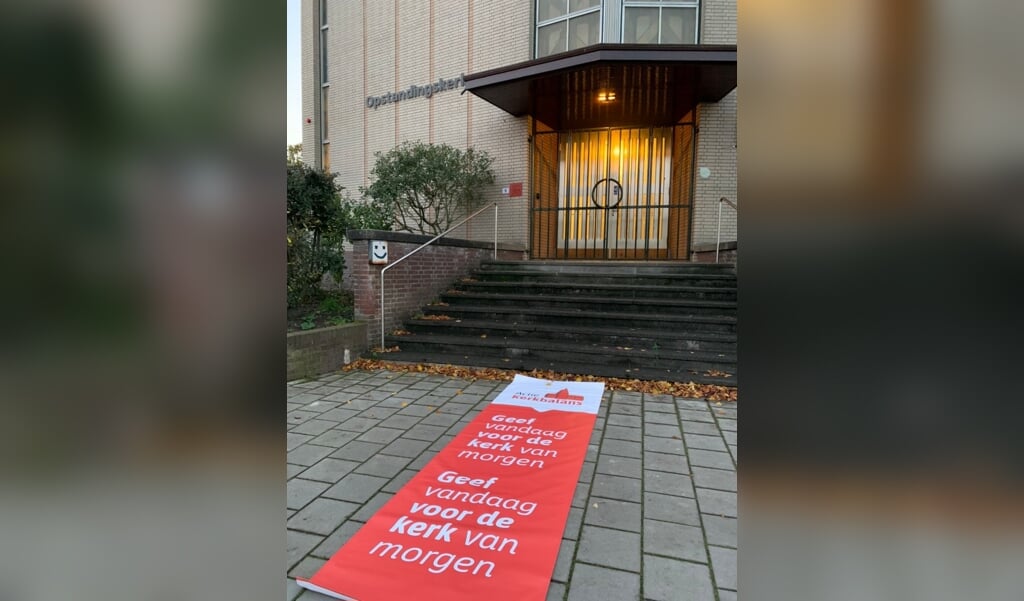 Actie Kerkbalans heeft rode lopers laten maken met de slogan ‘geef vandaag voor de kerk van morgen’, die kerken buiten voor de ingang kunnen uitrollen. (beeld actie kerkbalans)