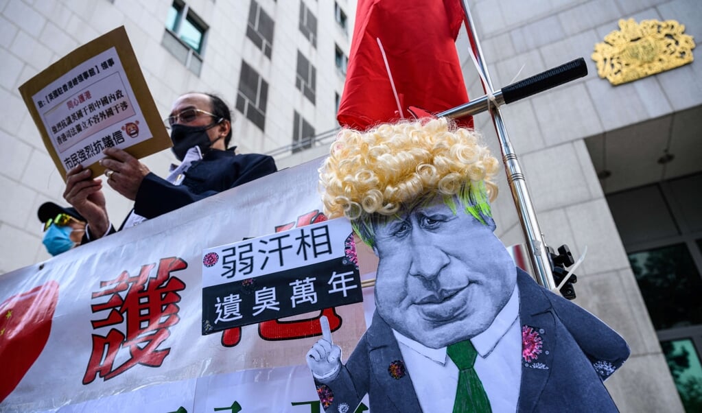 Een karikatuur van de Britse premier Boris Johnson tijdens een demonstratie van pro-Chinese activisten tegen het gebruik van het Britse overzees paspoort, waarmee inwoners van Hongkong toegang krijgen tot het Verenigd Koninkrijk; een toegang die overigens aan veel voorwaarden gebonden is.. (beeld Hollandse Hoogte / afp )