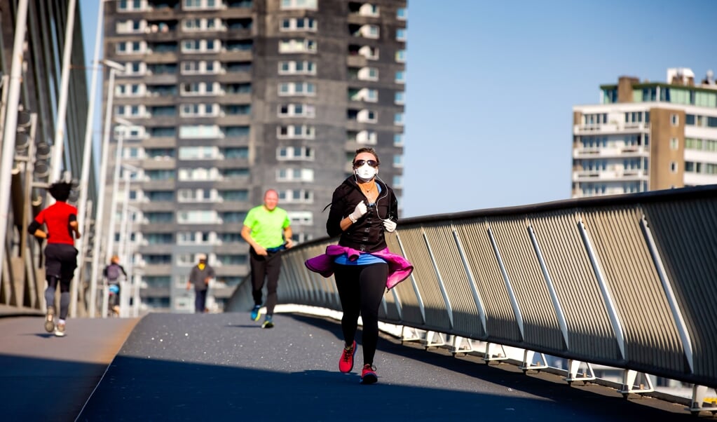 Hardlopers lopen over de Erasmusbrug in Rotterdam. Inmiddels telt Nederland meer dan een miljoen recreatieve hardlopers, aldus Olivier Heimel. (beeld anp / Bart Hoogveld)