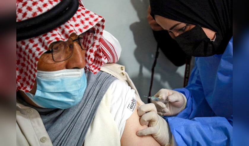 Een Syrische vluchteling krijgt een coronavaccin toegediend in het vluchtelingenkamp Zaatari. (beeld afp / Khalil Mazraawi)