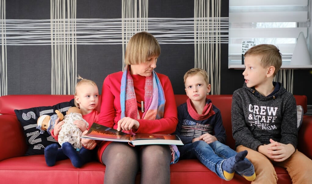 Margreet van den Berg leest voor uit een kinderbijbel, aan Krista (2), Hielke (5) en haar eigen zoon Wout (8). (beeld Dick Vos)