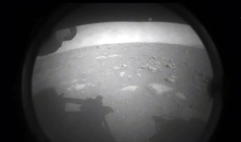 De eerste foto die de Perseverance vanuit Mars naar de aarde heeft verstuurd nadat de robotkar donderdagavond succesvol landde op de rode planeet. (beeld afp / nasa)