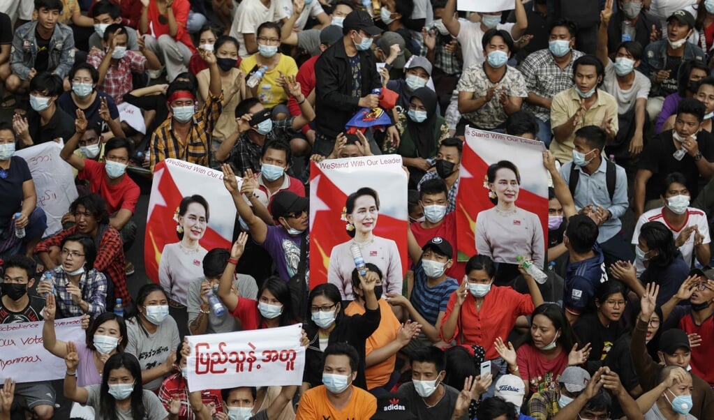 Demonstranten met foto's van Aung San Suu Kyi keren zich tegen de junta in de straten van Yangon. (beeld epa / Lynn Bo Bo)