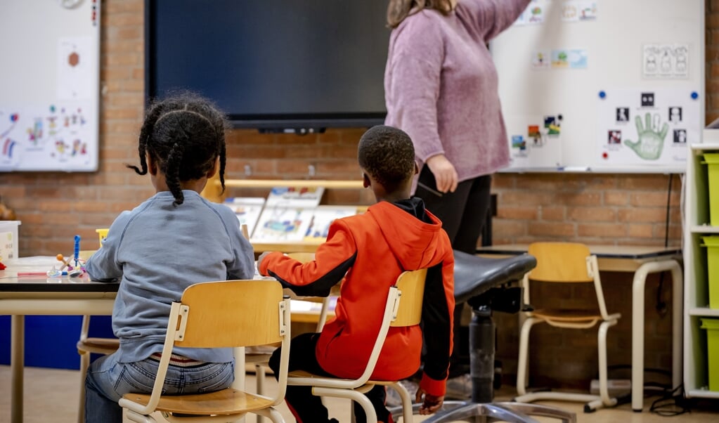 Leerlingen van de Van Houteschool voor speciaal basisonderwijs aan het werk. Een aantal kinderen gaat ondanks de lockdown toch naar school. (beeld anp / Robin van Lonkhuijsen)