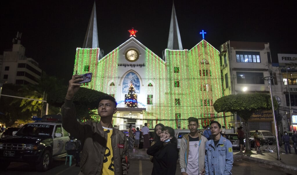 Jongeren nemen een selfie bij de Immanuel Baptist kerk in Yangon (Rangoon), de voormalige hoofdstad van Myanmar (Birma). (beeld afp / Sai Aung Main)