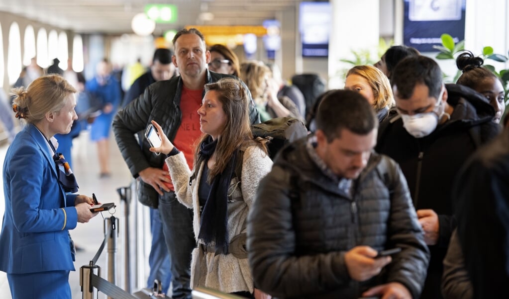 Archieffoto van drukte in de vertrekhal bij de informatiebalie van KLM op Schiphol. (beeld anp / Olaf Kraak)
