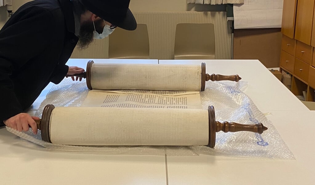 Rabbijn Jehoeda Vorst van de Nederlands-Israëlitische Gemeente Rotterdam onderzoekt de teruggevonden Thorarol. (beeld Kees Weltevrede)