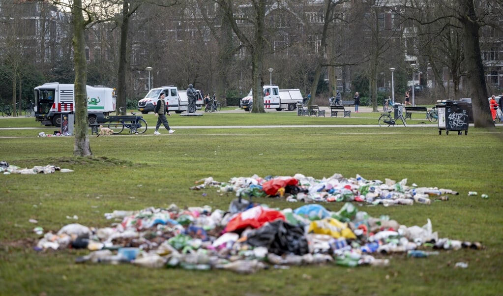 Gemeentemedewerkers hebben het afval bij elkaar geruimd dat werd achtergelaten door bezoekers van het Vondelpark. De politie greep er eerder in omdat het in het park te druk was en de coronamaatregelen niet werden nageleefd. (beeld anp / Evert Elzinga)