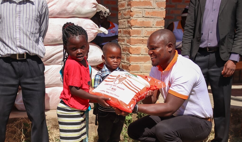 Hulpverlener Sungeni Ngonamo van Red een Kind geeft extra voedselhulp aan jonge gezinnen in Malawi tijdens de coronapandemie. (beeld Anneke Jagau)