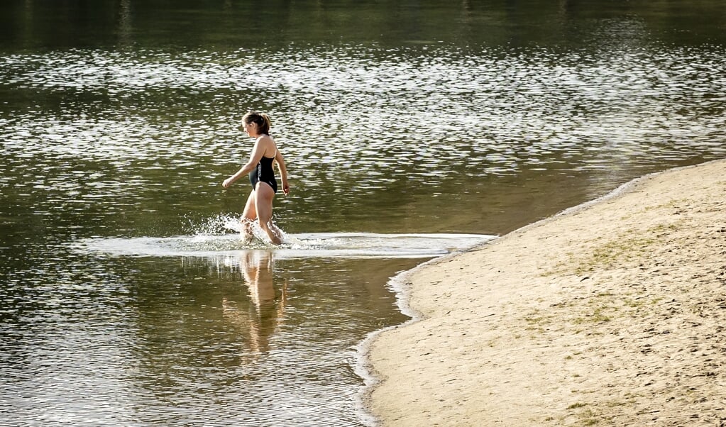 Vroege lente in Nederland: in badkleding het Henschotermeer in Woudenberg in, waar een week eerder nog ijs lag. (beeld anp / Remko de Waal)